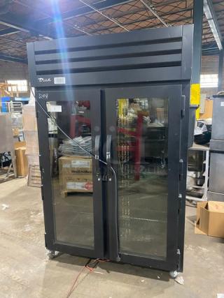 True commercial black double glass swing door reach-in merchandiser refrigerator, model STG2RPTVLD-2G-2S-HC, with poly-coated wire racks, SN 10547031, on casters.