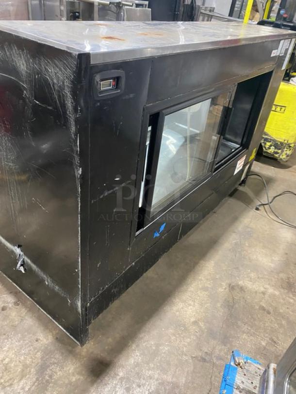 Tor-Rey black refrigerated bakery display, model TEM-200NG, with curved glass and rear double sliding door; used condition, visible scratches.