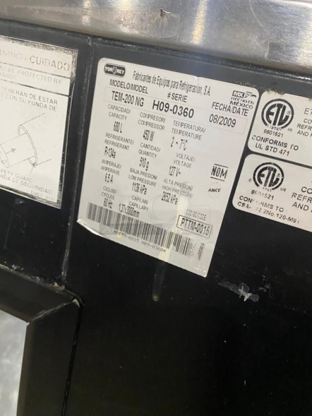 Tor-Rey TEM200NG black bakery merchandiser, model SN: H09-0360, 127V, curved glass, rear sliding door, label details visible.