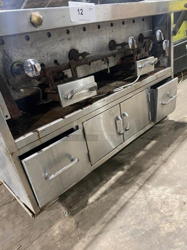 Commercial stainless steel Chitwood smoker/char broiler grill with pan slide, enclosed storage base, and casters. Natural gas/charcoal powered. Signs of wear visible.
