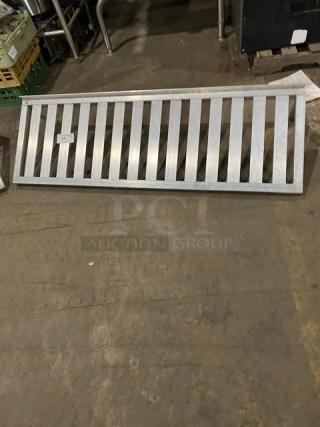 Commercial aluminum T-bar wall shelf, metal construction, horizontal slats, used condition, ideal for kitchen or industrial use.