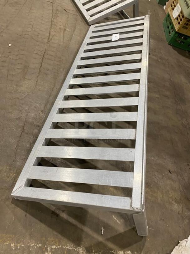 Commercial aluminum T-bar wall shelf with a slatted design. Sturdy construction, lightly used, suitable for large storage needs.
