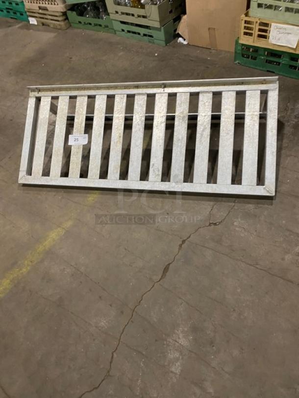 Commercial aluminum T-bar wall shelf with a slatted design, in used condition, featuring a visible label with item number 25.