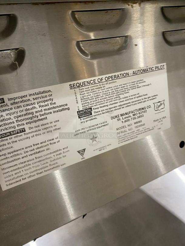 Duke Manufacturing AeroHot Series Model WB303 stainless steel 3-well hot food table with label detailing operation, on casters.