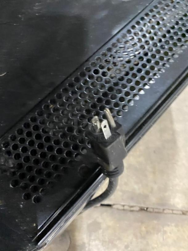 Black perforated metal panel with attached power cord on the 2020 Model 189MAC26HC refrigerated merchandiser.
