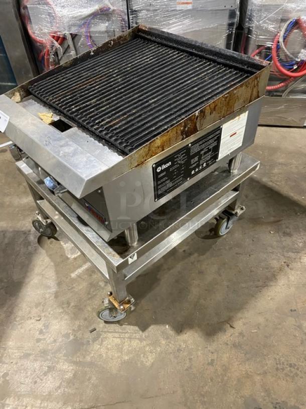 Ikon stainless steel natural gas char broiler on legs with open base stand and casters. Used condition. Model label visible.