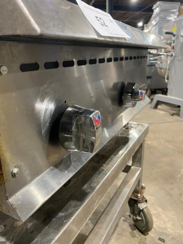 Ikon stainless steel natural gas-powered char broiler, countertop model on legs, with open base stand and casters, visible control knobs.