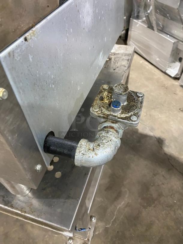 Ikon stainless steel gas char broiler with open base stand, on casters. Visible gas connection detail, slight wear.