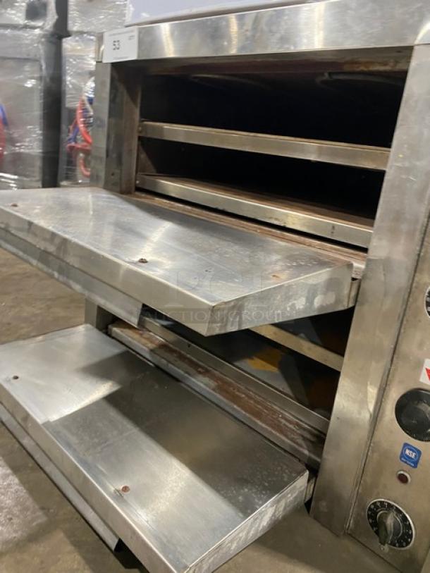 Commercial stainless steel electric countertop pizza/deck oven with thermostatic controls, two decks, and wear marks.