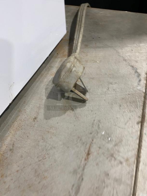 Commercial stainless steel electric countertop pizza oven with thermostatic controls. Power cord plug shown.
