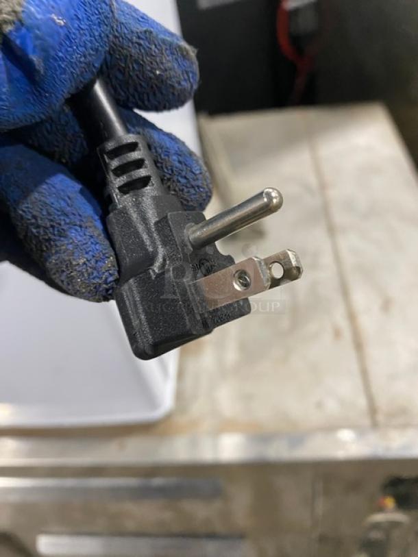 Close-up of a black power plug for the Danby Commercial Refrigerator, model DAR026A1WDD. 115V, in good condition.