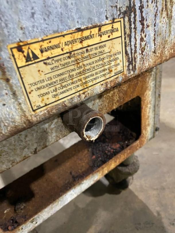 Pitco commercial stainless steel deep fat fryer, natural gas powered, with back splash, basket hanger, and casters. Warning label present.