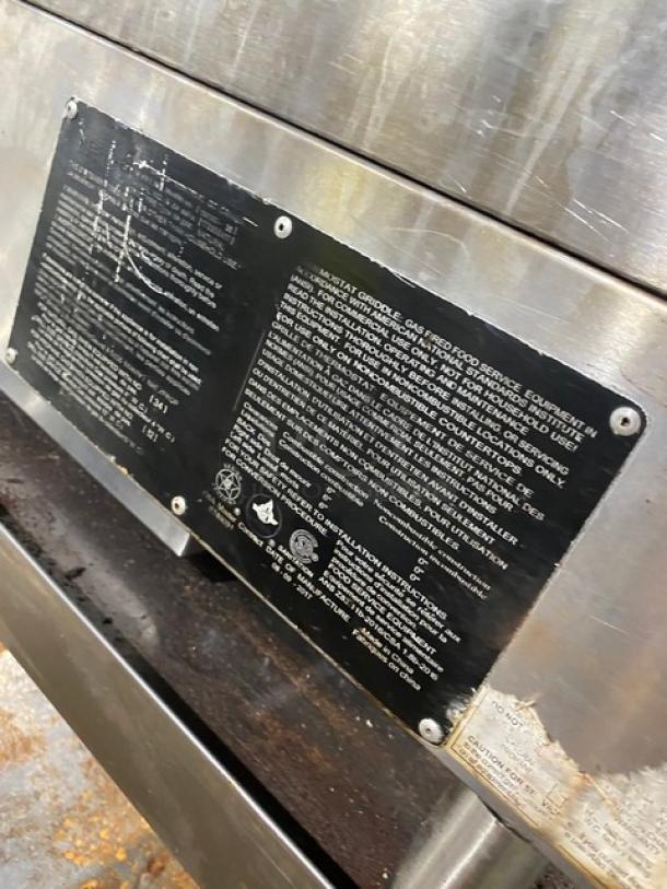 Sierra 2017 stainless steel natural gas countertop flat griddle with thermostatic controls, undershelf stand, and casters. Slight wear visible.