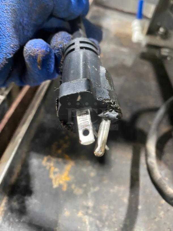 Close-up of a damaged power plug for Waring WPC100 pasta cooker, highlighting melted areas on the prongs.