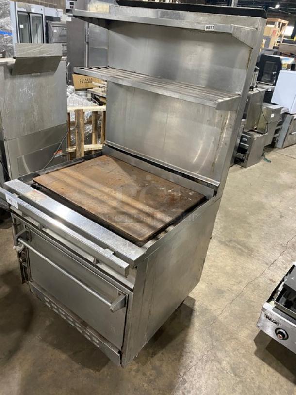 Jade Range commercial stainless steel flat top range/oven combo with backsplash, double overhead shelf, and wired oven rack on casters.