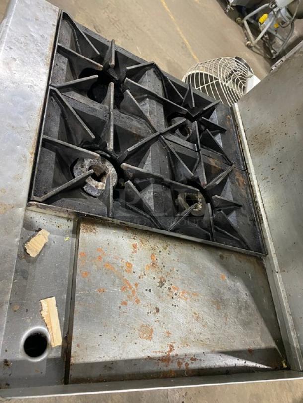 Commercial stainless steel 4-burner split top gas griddle range/oven combo with backsplash and overhead salamander broiler. Slight wear.