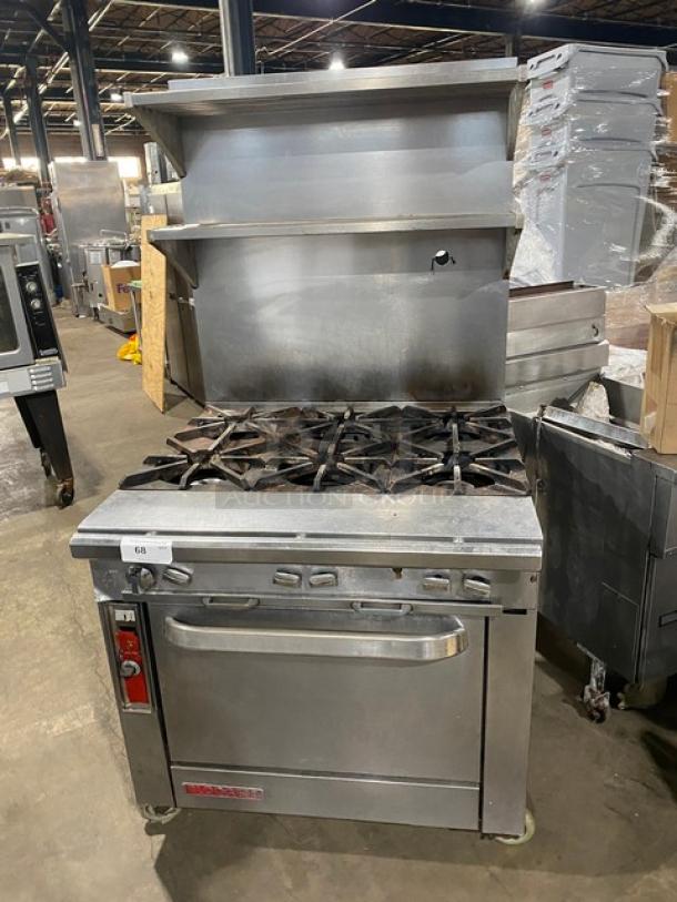 Blodgett commercial stainless steel gas-powered 6-burner range/oven combo. Features backsplash, double overhead shelf, wired oven racks, and casters.