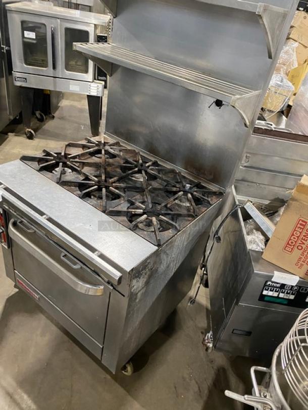 Blodgett commercial stainless steel gas 6-burner range/oven combo with backsplash, double overhead shelf, wired racks, on casters.