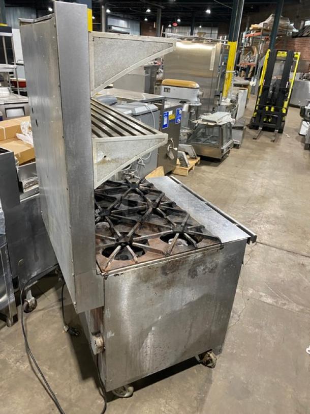 Blodgett commercial stainless steel gas-powered 6-burner range/oven combo with backsplash, double overhead shelf, wired oven racks, on casters.