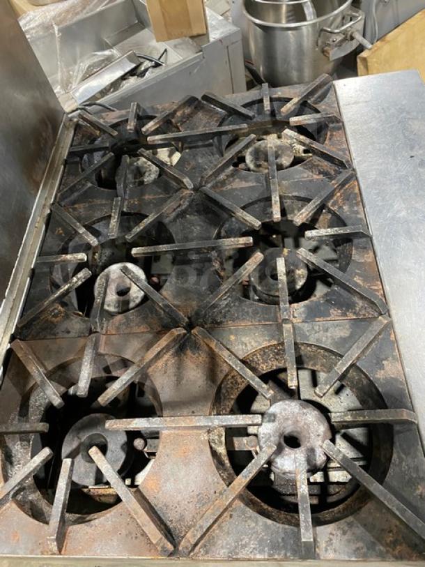 Blodgett commercial stainless steel 6-burner gas range/oven with backsplash and double shelf. Features wired oven racks on casters. Used condition.