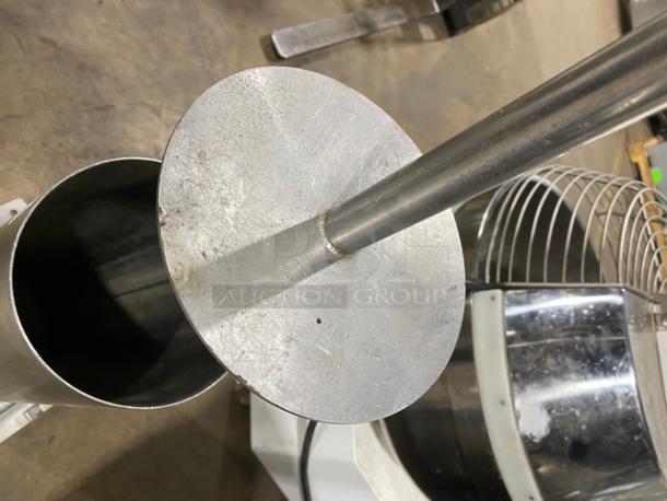 Commercial stainless steel manual mincer with black grip handle, shown with cylindrical hopper and flat pusher.