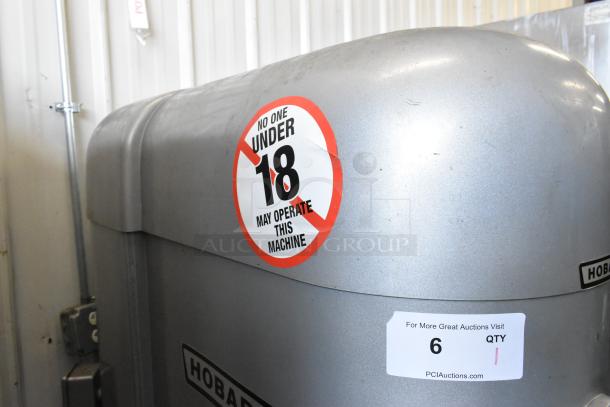 Hobart M802 metal commercial mixer detail, showing age restriction and auction label. 80-quart, includes attachments.