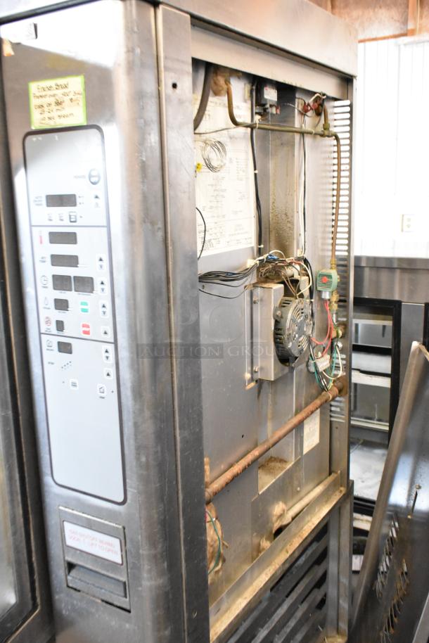 Baxter stainless steel commercial mini rotating rack oven with dual pan rack on casters, visible control panel and internal wiring.