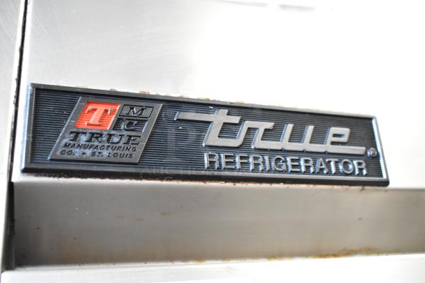 True TS-49 stainless steel commercial cooler, 2-door, with poly coated racks, on casters. Logo badge visible.