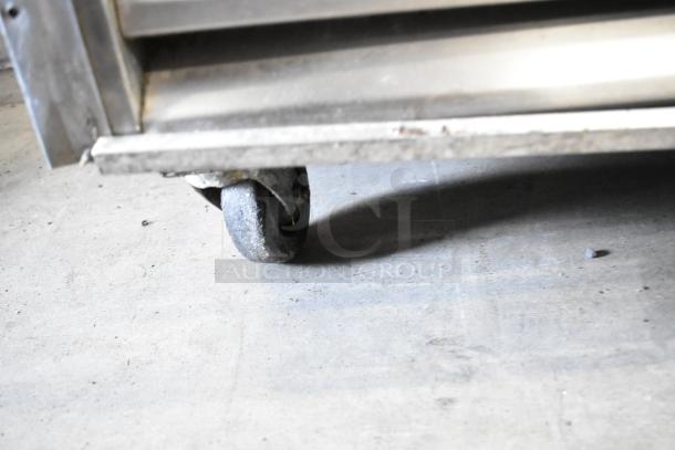 Close-up of caster wheel on a True TS-49 stainless steel commercial 2-door reach-in cooler. Rugged, durable, mobile.