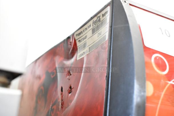 True GDM-45 commercial cooler, metal exterior, visible worn Coca-Cola branding, property tag displayed.