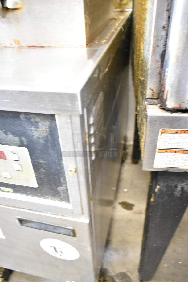 Henny Penny 600 stainless steel gas pressure fryer on casters, worn exterior, visible control panel. 80,000 BTU.