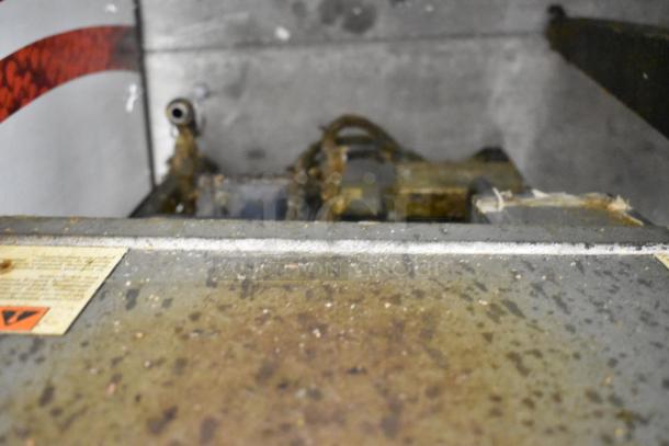 Henny Penny 600 stainless steel pressure fryer, 80,000 BTU, natural gas, on commercial casters. Visible wear and usage signs.