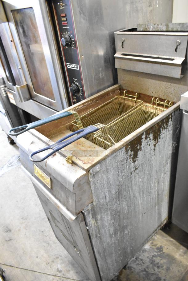 Qualite QL-9/NG stainless steel gas fryer, 90,000 BTU, includes 2 metal baskets, visible wear, commercial kitchen setting.