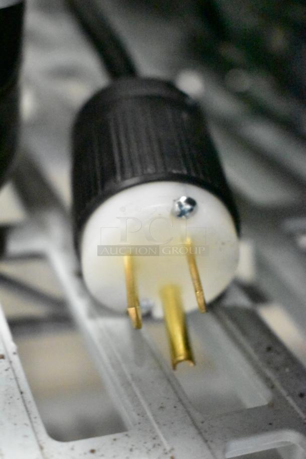 Power plug of Rossi RR45 espresso bean grinder showing prongs and black grip, indicates 115 volts, 1 phase connection.