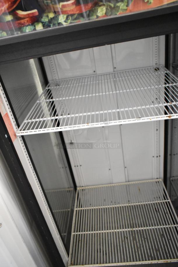 True GEM-26 commercial reach-in cooler with poly coated racks, single door, shows some rust, 115V, 1 phase.