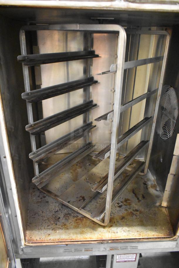 Baxter stainless steel mini rotating rack oven, natural gas-powered, includes double pan rack and commercial casters, used condition.