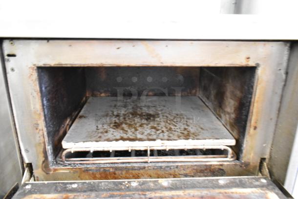 Turbochef NGC stainless steel commercial rapid cook oven interior, shows wear. Mounted on equipment stand with casters.
