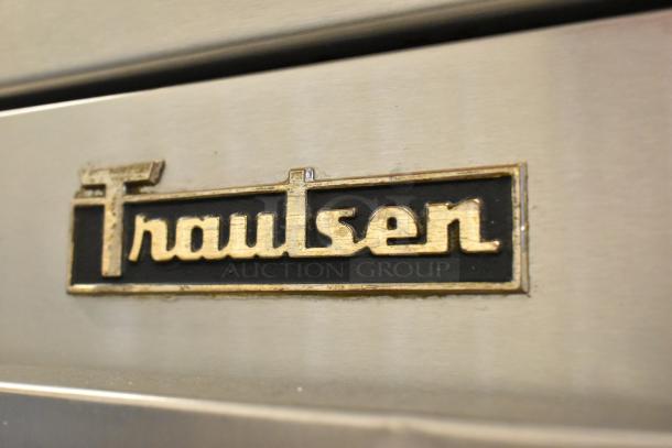 Traulsen G10010 stainless steel commercial cooler with single door, poly coated racks, on casters. Brand logo on front.