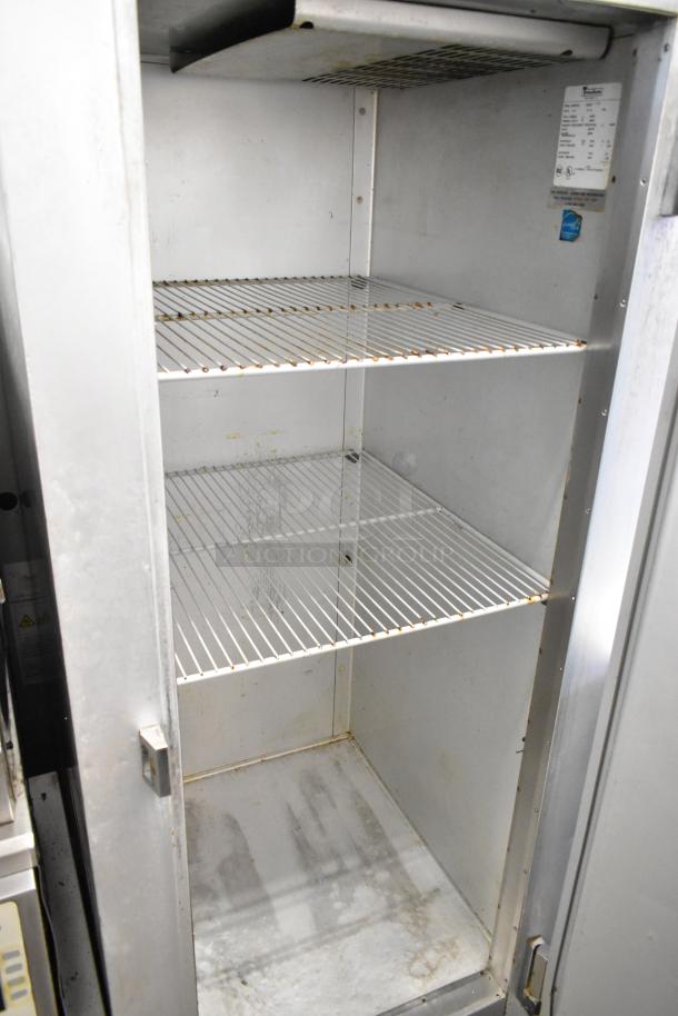 Traulsen G10010 stainless steel commercial single door reach-in cooler with poly coated racks, visible interior condition, on casters.