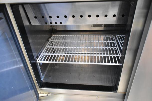 Everest EPBR2 stainless steel prep table interior, showcasing wire shelving and sneeze guard, on commercial casters. 115V, 1 Phase.