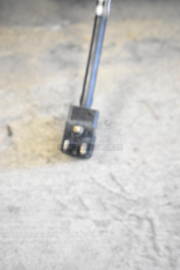 Blurry close-up of a plug from a Randell 941452D7 stainless steel commercial prep table, used in restaurant settings.