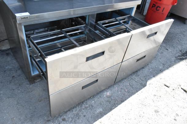 Delfield UCD4464N-12-DD stainless steel prep table, 4 drawers, over shelf, commercial casters, visible model label.