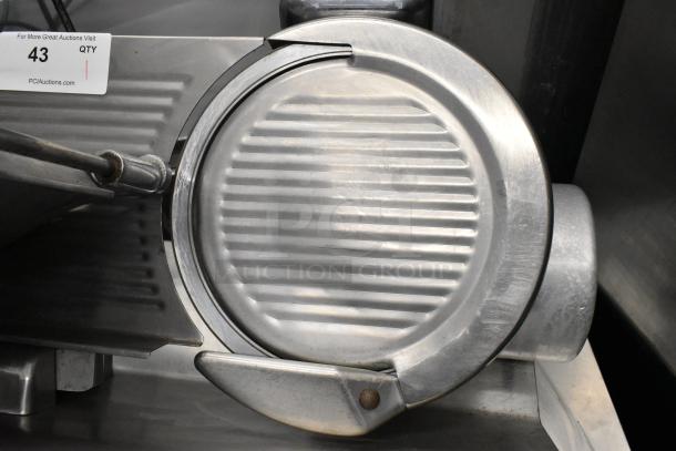 Globe 400 stainless steel commercial meat slicer with blade sharpener. Features 115 volts, 1 phase. Visible tag shows auction info.