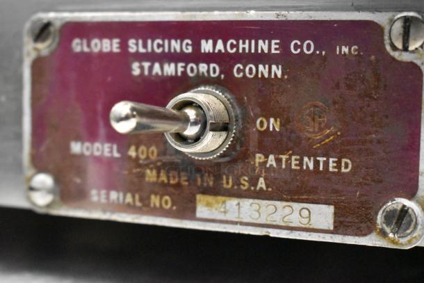 Stainless steel Globe Model 400 meat slicer tag showing serial number and manufacturing details in Stamford, Conn., USA.