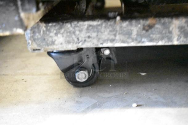 True GDM-41 cooler on commercial caster, close-up of wheel. Ideal for mobility. Metal exterior, sturdy construction.