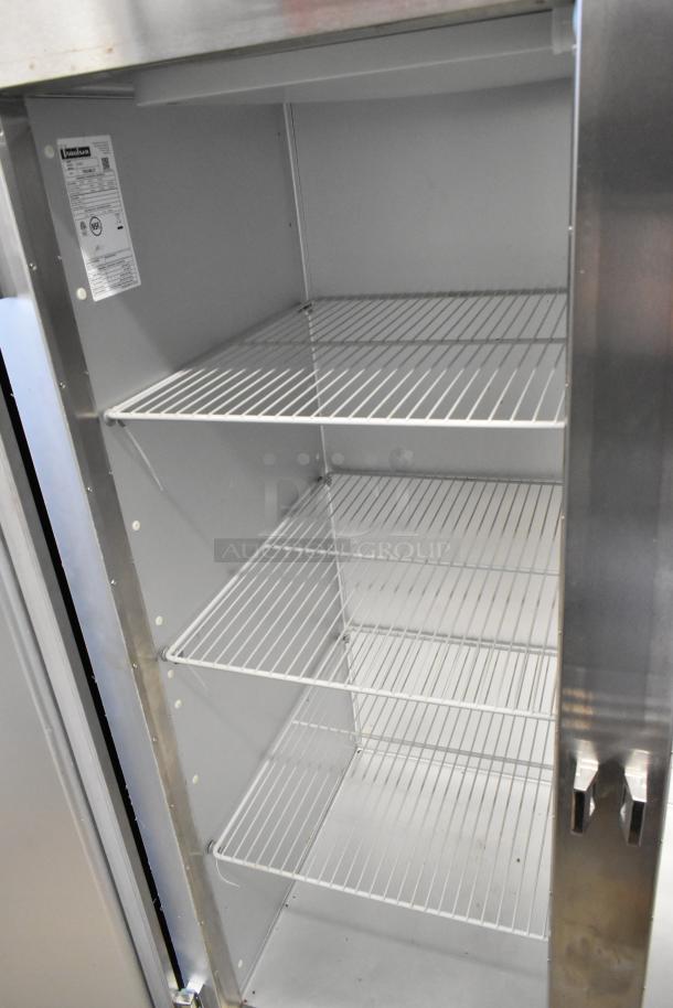Traulsen G20010 stainless steel commercial 2-door reach-in cooler with poly-coated racks, on casters. Model info visible inside.