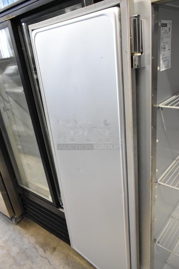 Traulsen G20010 stainless steel commercial cooler, two doors, visible scuffs, poly-coated racks, commercial casters.
