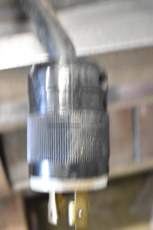 Blurry image showing the power plug of a Hoshizaki KML-631MAH commercial ice machine. 208-230V, 1 phase.