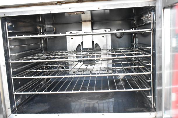 Vulcan VC4GD stainless steel convection oven, gas-powered, view doors, metal racks, thermostatic controls, on casters.