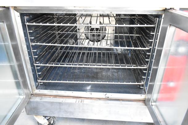 Vulcan VC4GD stainless steel commercial gas convection oven, view-through doors, metal racks, thermostatic controls, on casters.